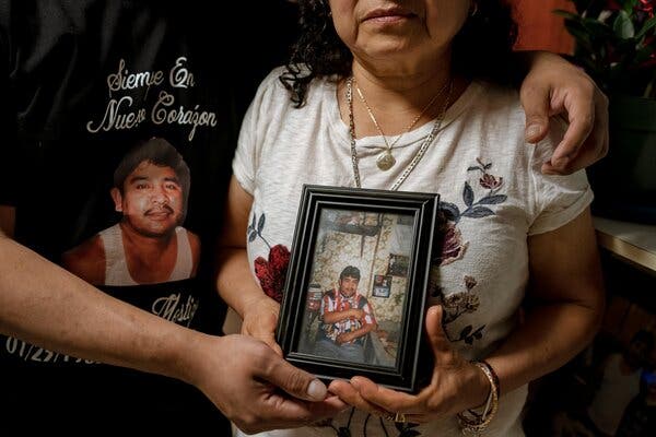 Juan Cruz Jr. and his mother, Delfina Cruz, with a portrait of his father, who died of Covid-19 while awaiting trial in a New York jail.