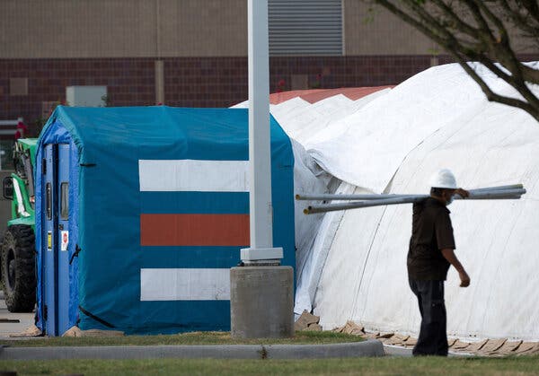 Construction workers setting up tents outside Lyndon B. Johnson Hospital in Houston on Monday. Officials plan to use the tents to handle an overflow of Covid patients.