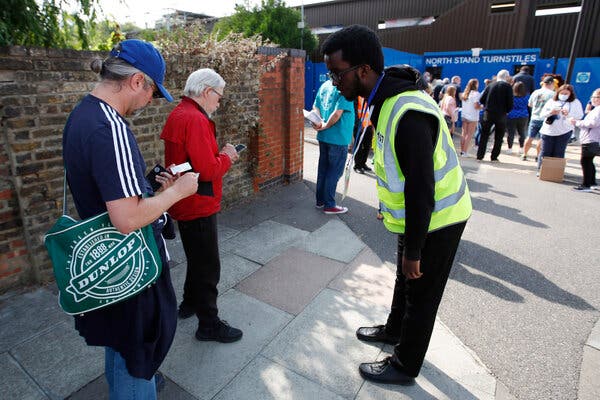 Soccer fans showed their Covid vaccination cards to a security officer at a soccer match in London on Sunday. While Britain has scrapped any immediate plans for vaccine passports, venues may still require proof of vaccination. 