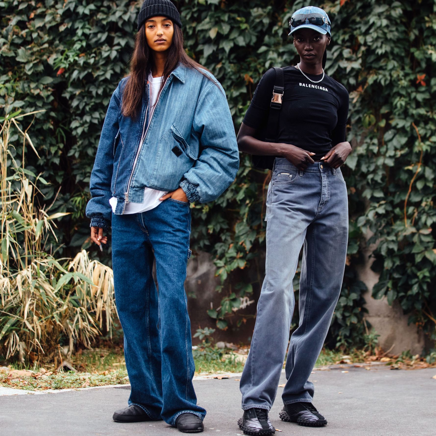 two models wear denim outside of new york fashion week shows to illustrate a roundup of the best denim deals during black friday 2021