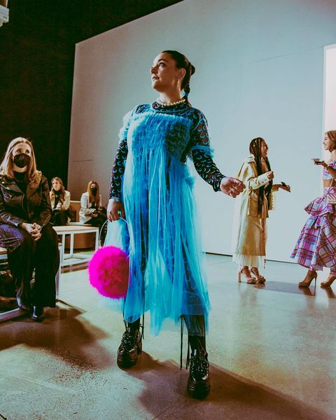 a brunette woman in a blue tulle dress and boots
