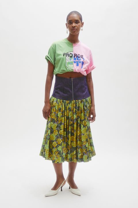 a black woman with short hair wears a t shirt reading pro roe and a floral skirt
