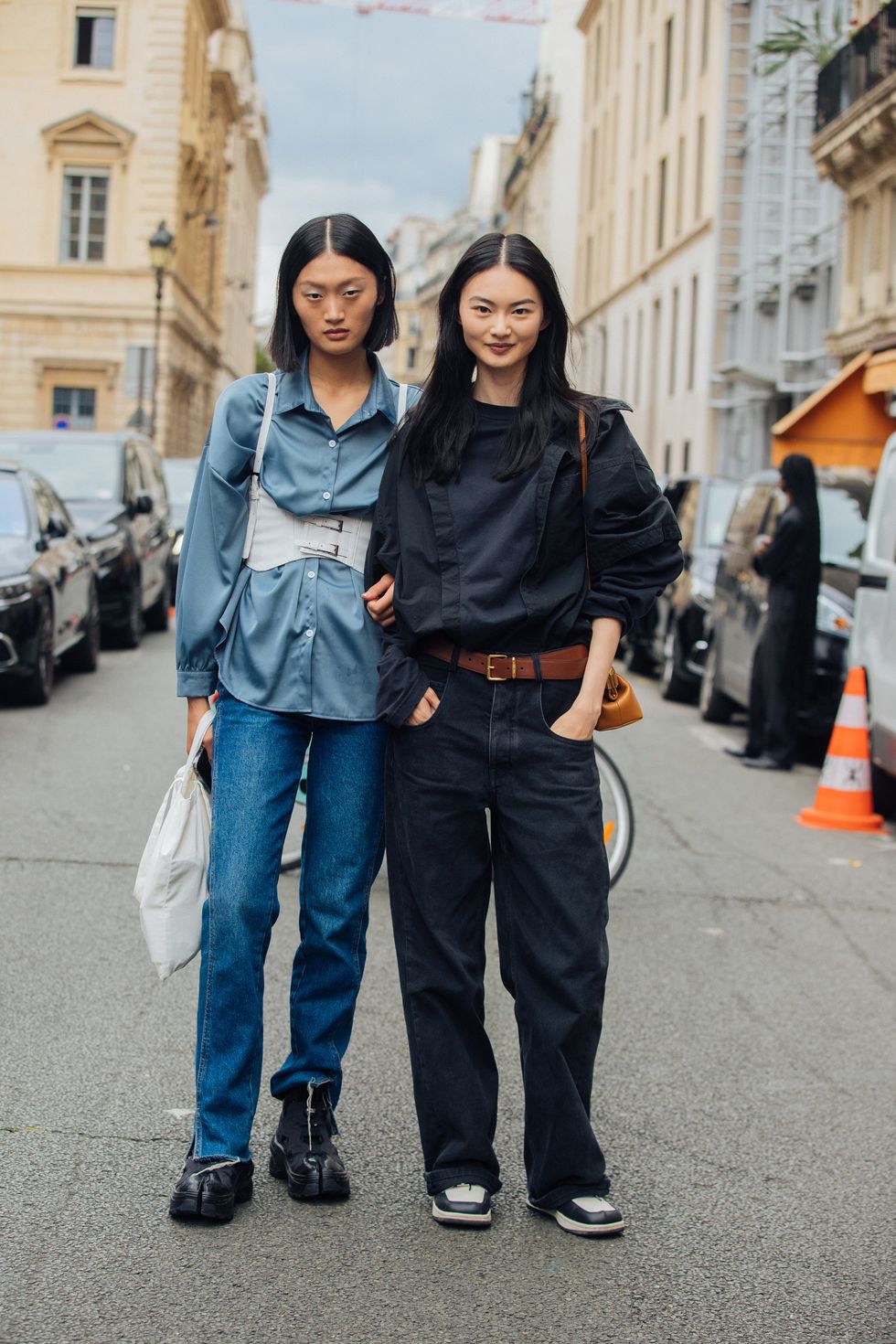 paris, france july 07 chinese models yilan hua and he cong at the fendi show at palais brongniart during couture fashion week fallwinter 2022 on july 07, 2022 in paris, france yilan l wears a blue shirt with a with harness, blue jeans, and black reebok maison margiela tabi instapump fury oxford shoes he cong r wears a black shirt with front folds, brown belt, boxy blue jeans, and nike sneakers photo by melodie jenggetty images