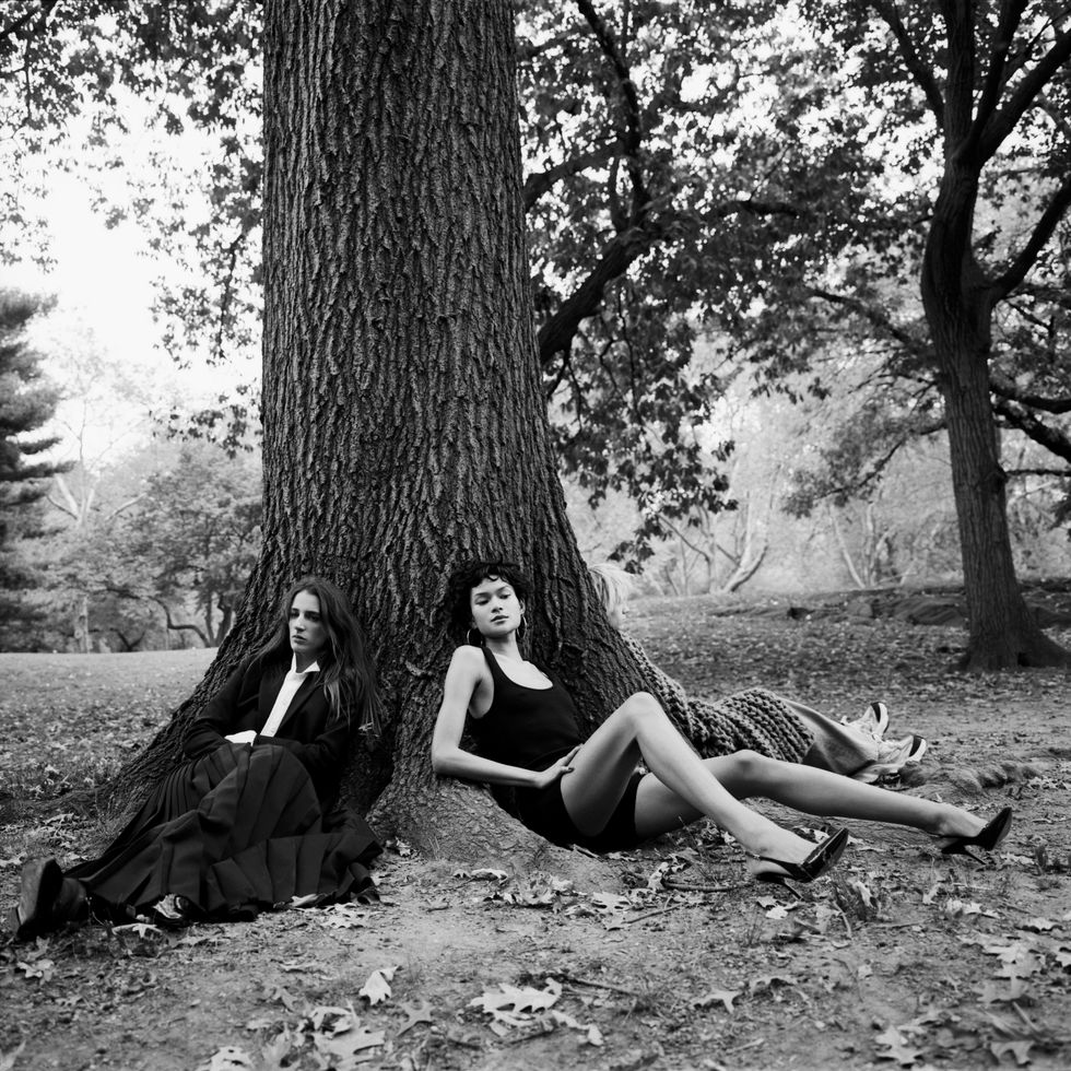 two models sit under a tree