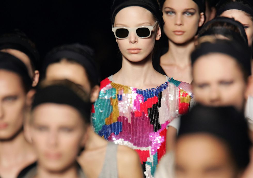 a model in a group of women, wearing a multicolored sequined top