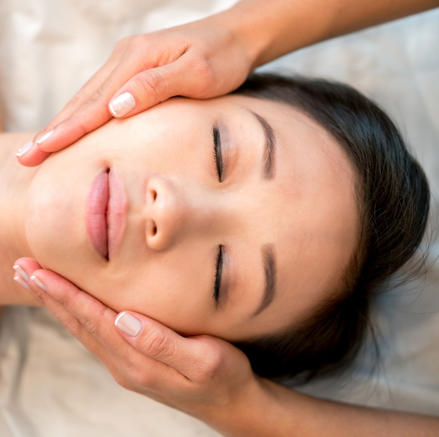 asian woman getting a face massage at the spa