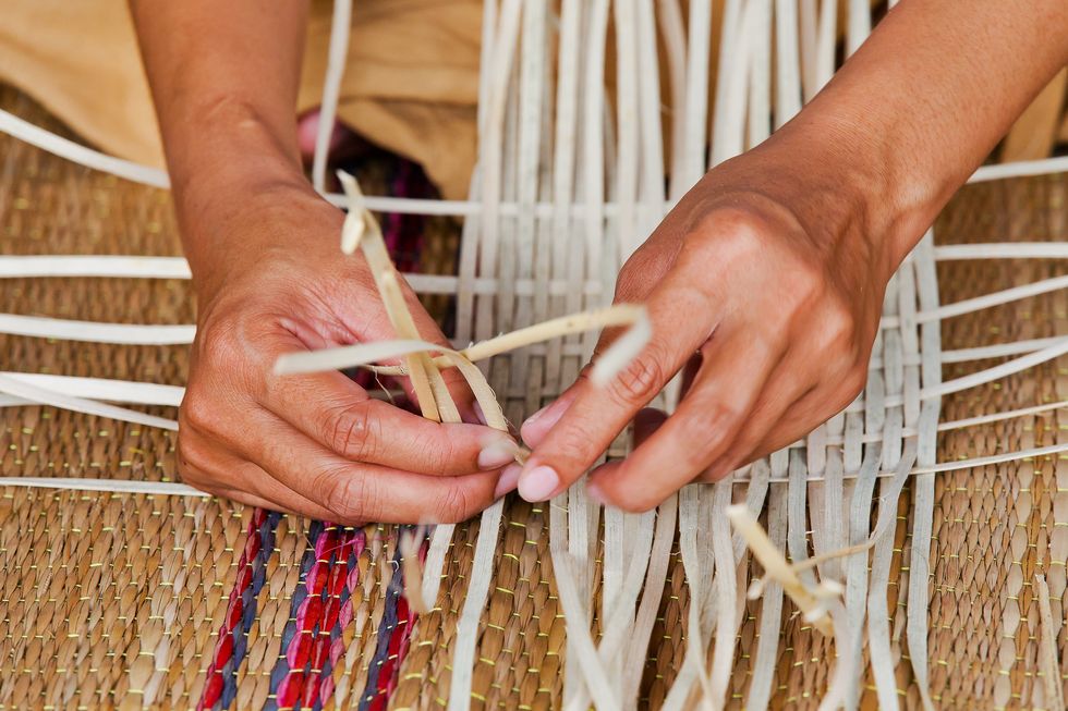 thai traditional strips of bamboo weaving with human hands