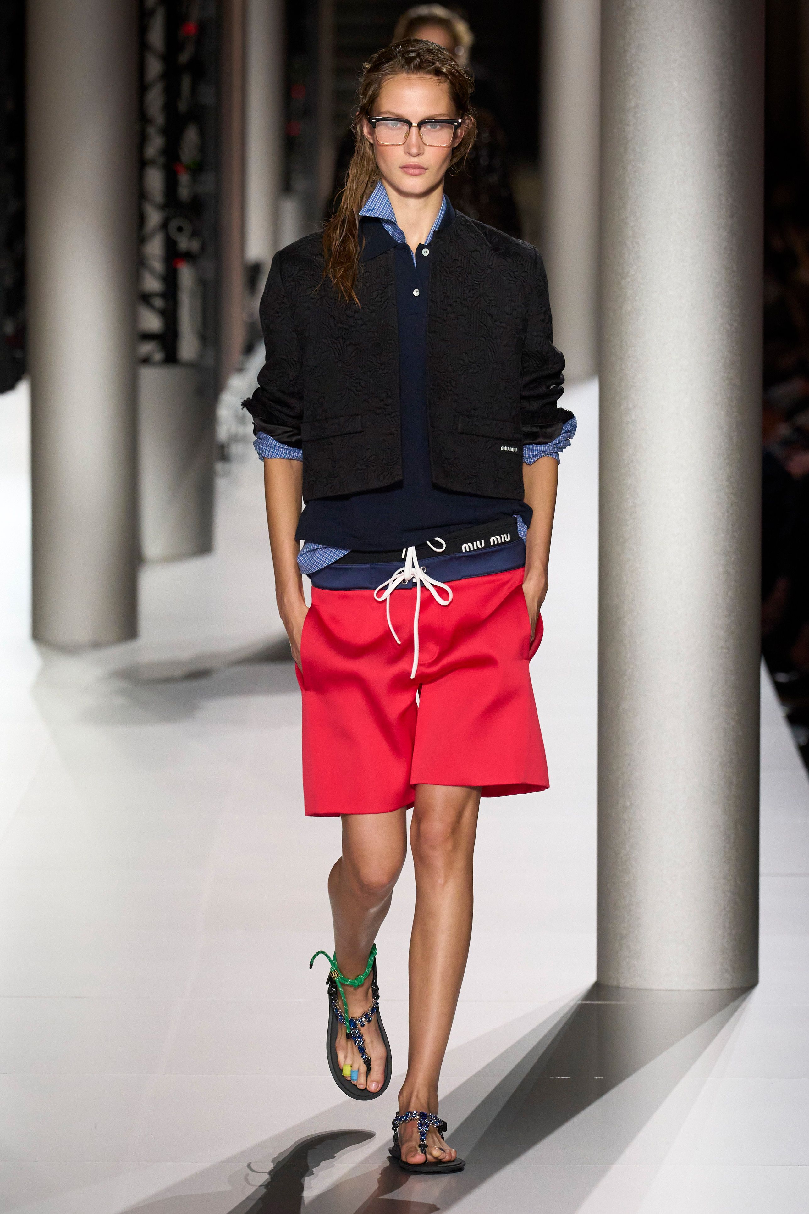 a woman wearing a black shirt and red skirt