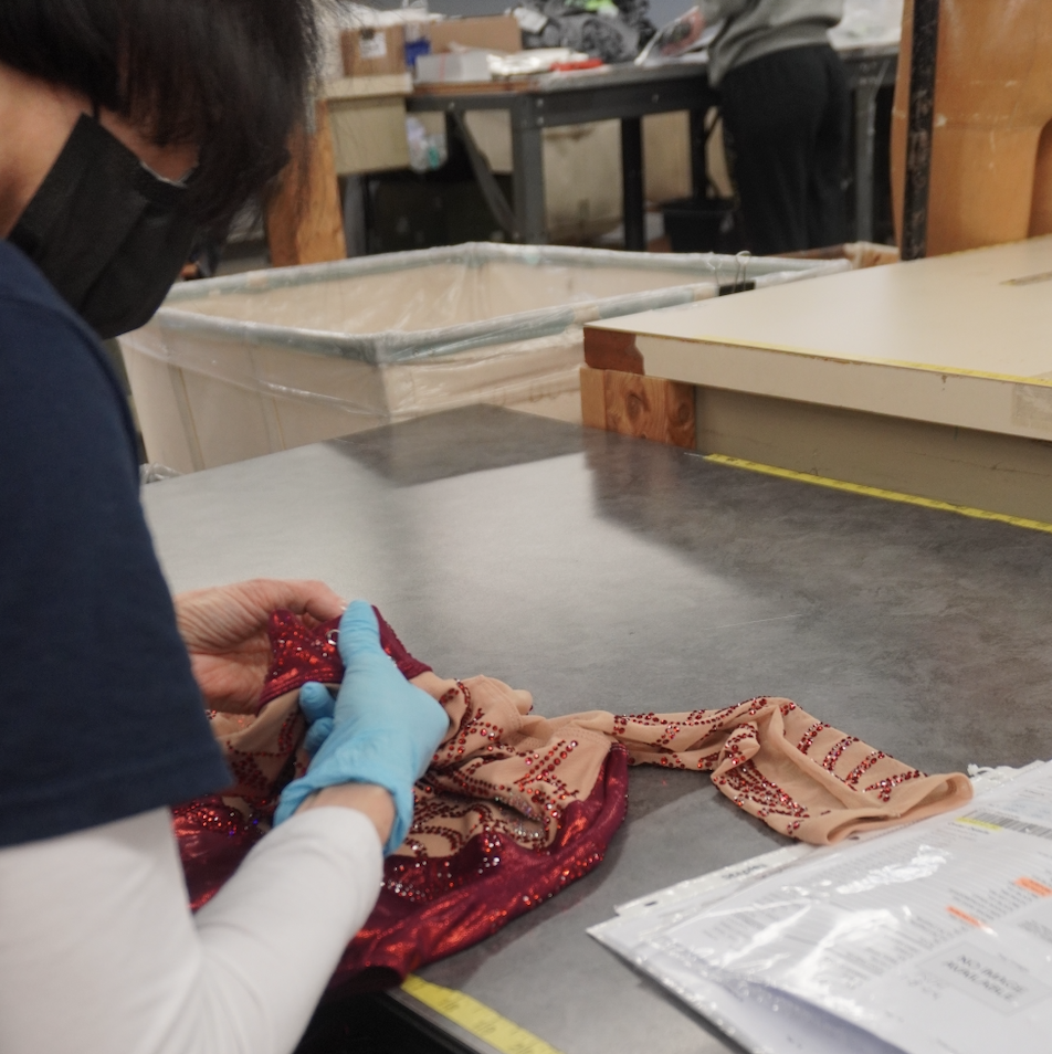 a person sewing crystals on a leotard