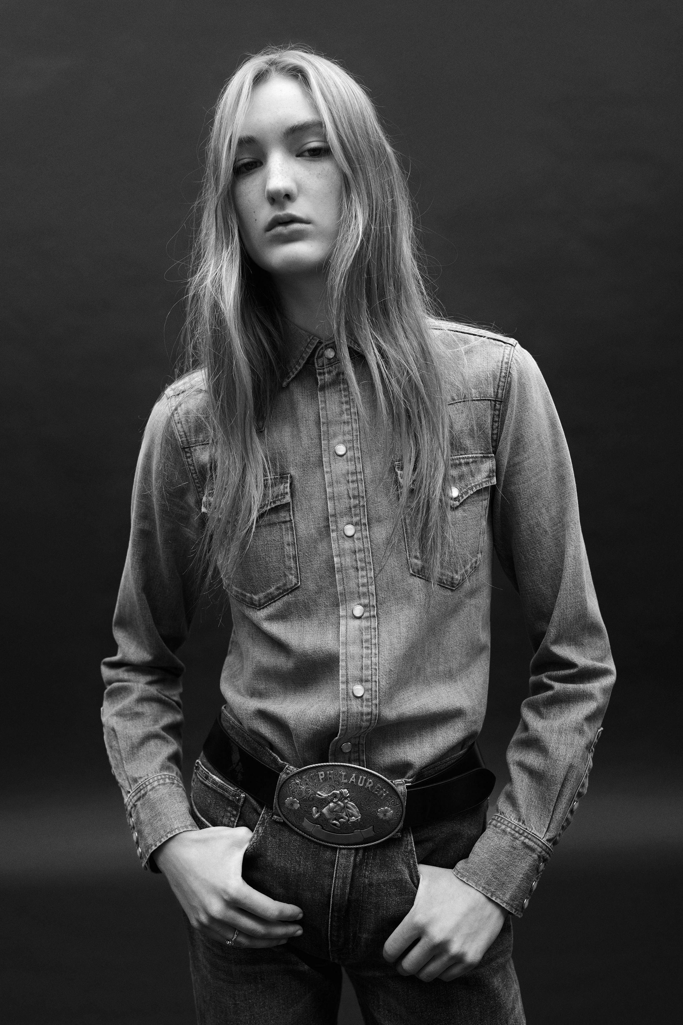 a woman wearing a denim shirt and western belt