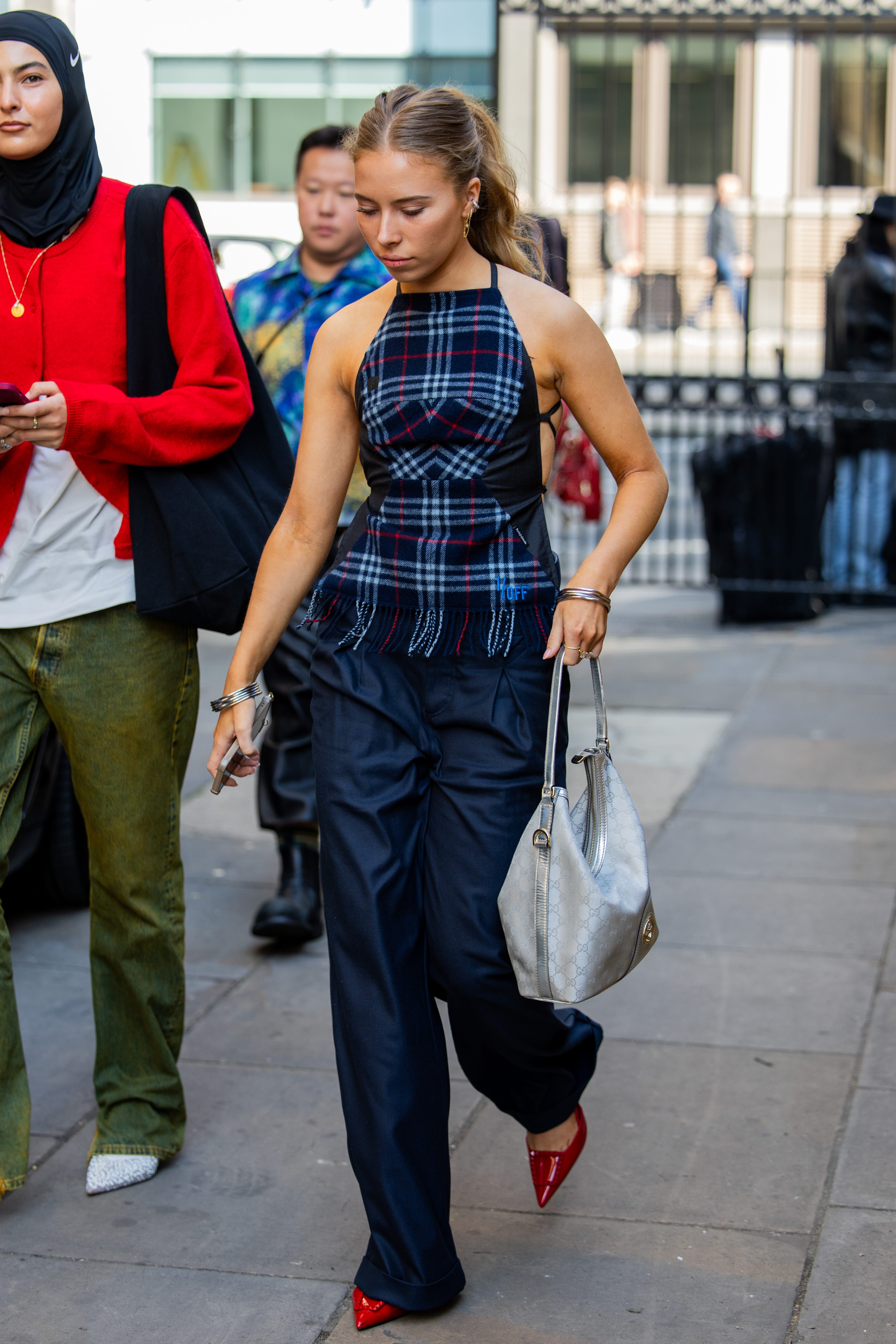 london, england september 15 a guest wears checkered top, navy pants, grey bag outside jw anderson during london fashion week september 2024 on september 15, 2024 in london, england photo by christian vieriggetty images