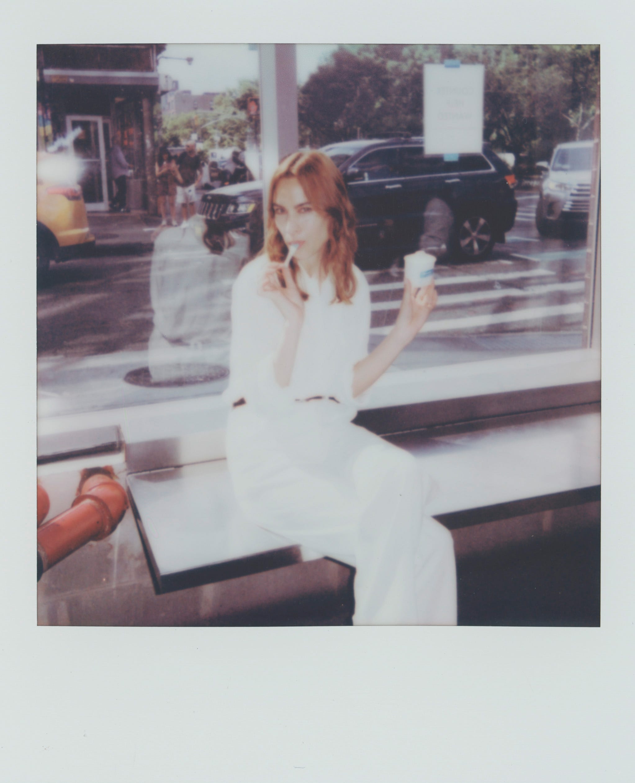 a woman dressed in white eating ice cream