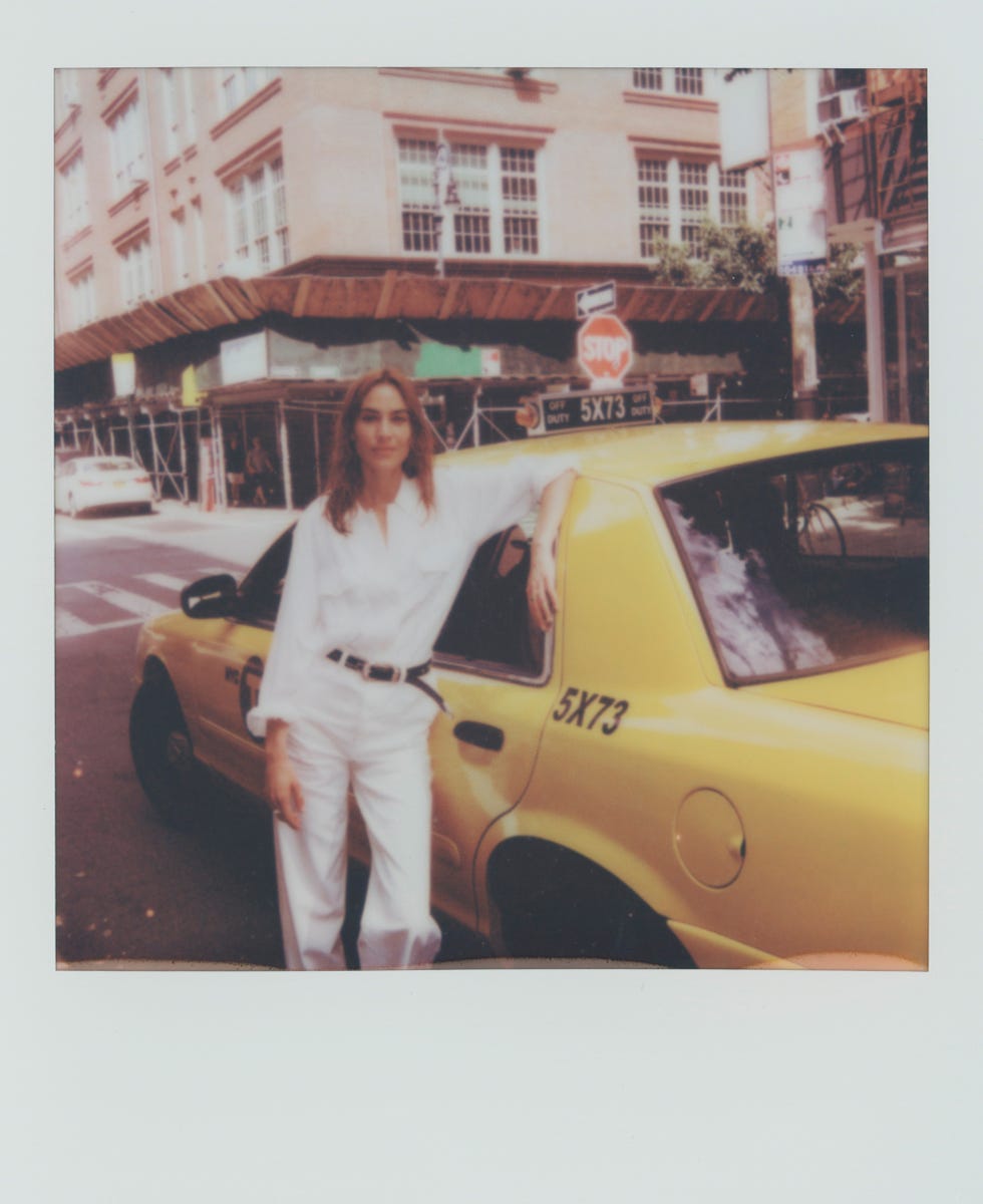 a woman posing with a yellow taxi cab