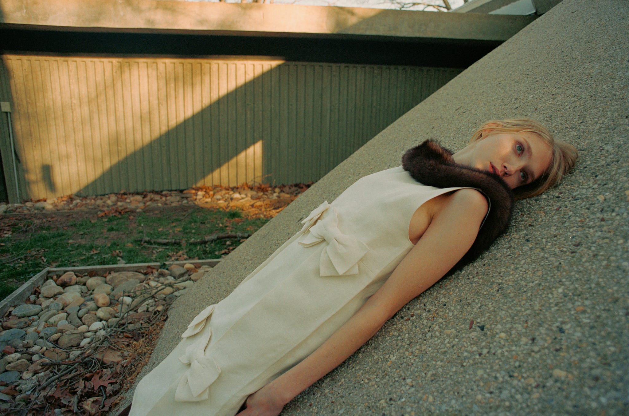 a woman leaning on the side of a building