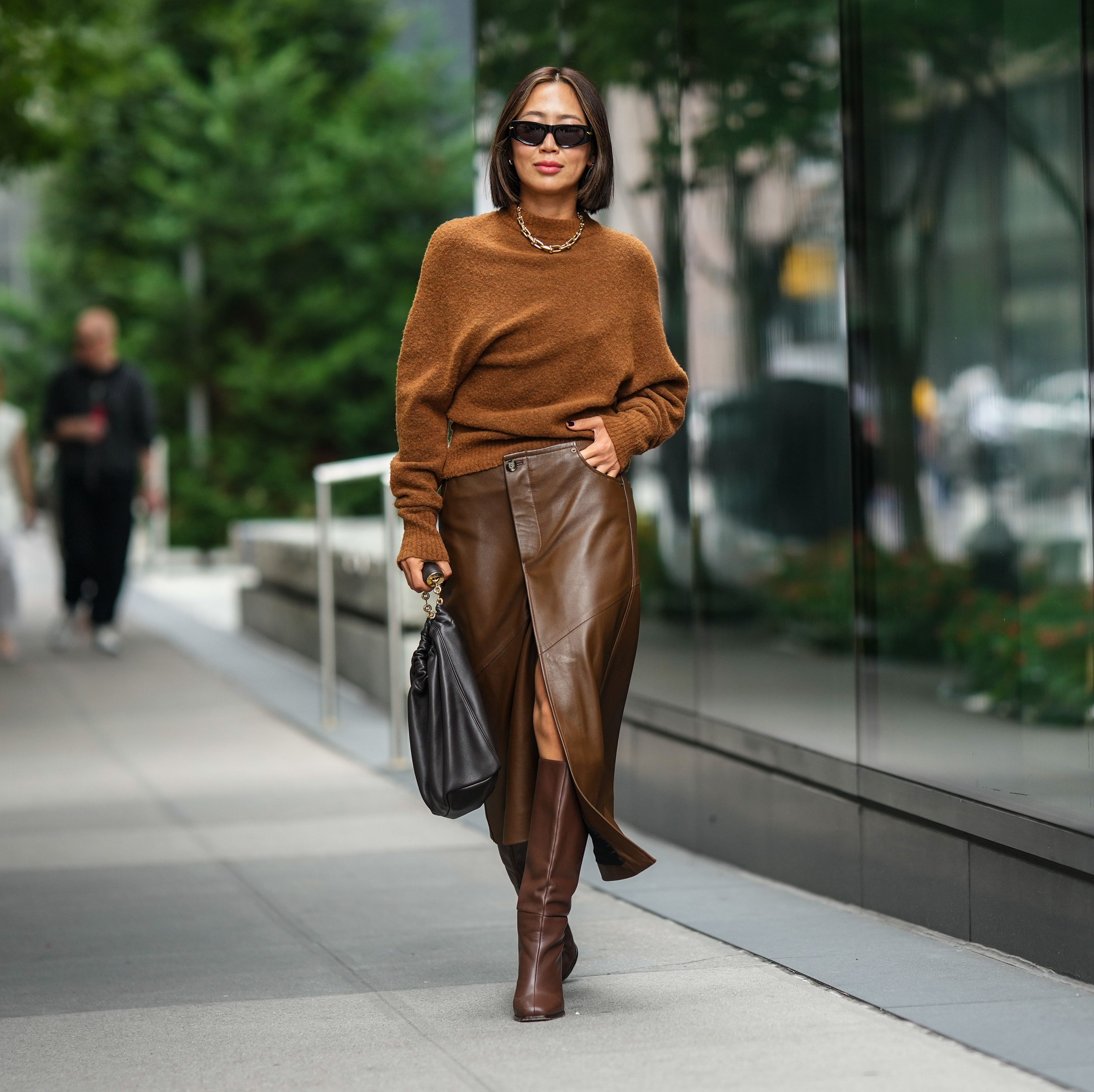 new york, new york september 09 aimee song wears sunglasses, a necklace, a brown wool pullover, a brown leather skirt, a black leather bag, brown knee high boots, outside proenza schouler, during new york fashion week, on september 09, 2023 in new york city photo by edward berthelotgetty images