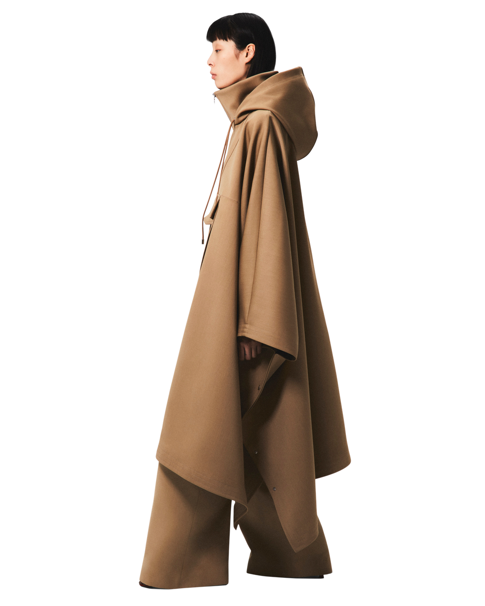 a woman wearing a tan caped coat