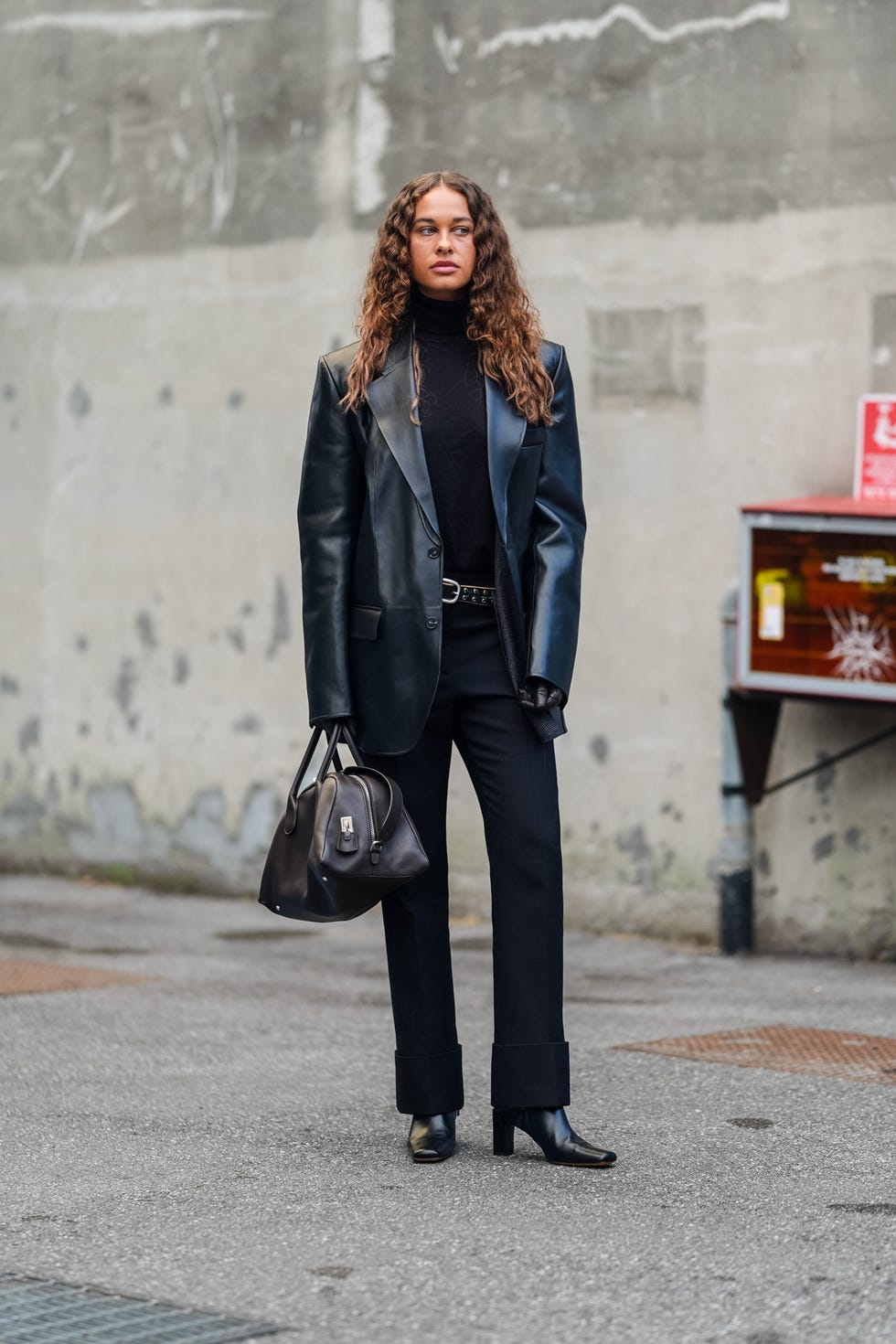 milan, italy september 20 sarah lysander wears black turtleneck long sleeve tod's shirt, shiny black leather jacket, black leather belt, shiny black tod's leather bag, shiny black heeled leather boots, outside tod's, during the milan fashion week springsummer 2024 2025 on september 20, 2024 in milan, italy photo by edward berthelotgetty images