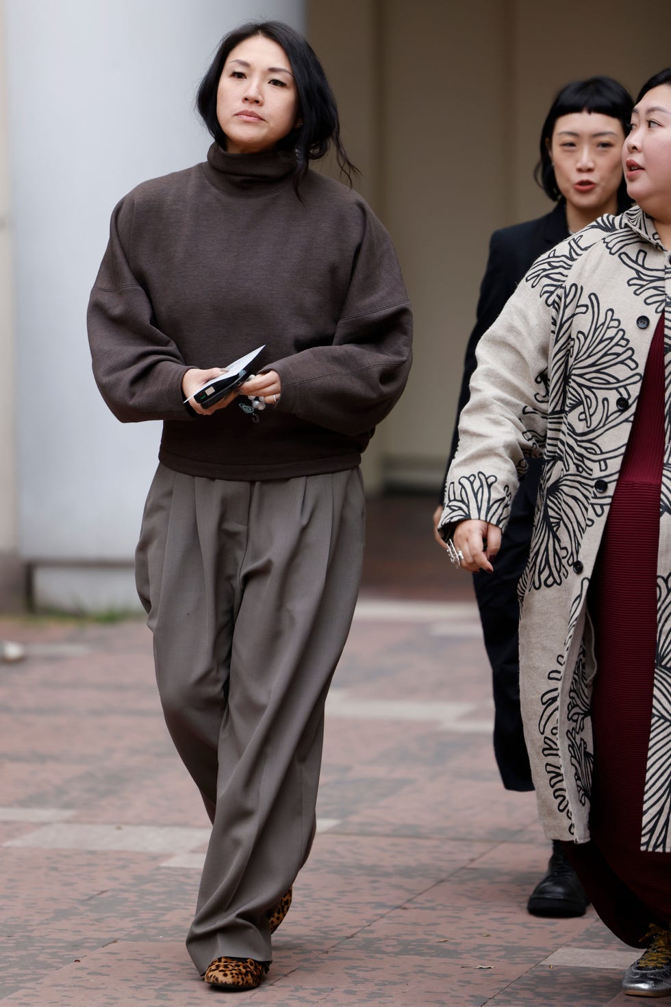 paris, france september 30 a guest wears brown jumper, taupe trousers, outside sacai, during womenswear springsummer 2025 as part of paris fashion week on september 30, 2024 in paris, france photo by claudio laveniagetty images