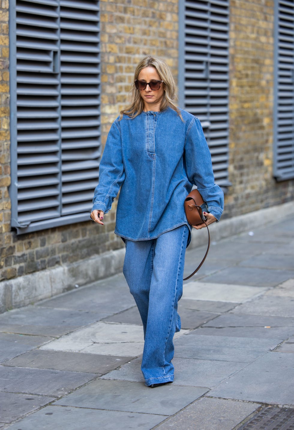 london, england september 15 a guest wears denim shirt, jeans, brown bag outside jw anderson during london fashion week september 2024 on september 15, 2024 in london, england photo by christian vieriggetty images