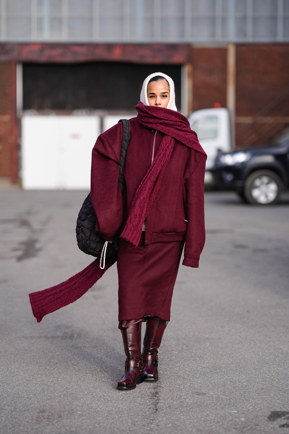 copenhagen, denmark february 01 a guest wears a white balaclava, a burgundy full outfit, a long oversized scarf, an oversized jacket with shoulder pads, a midi skirt , leather boots , outside gestuz, during the copenhagen fashion week aw24 on february 01, 2024 in copenhagen, denmark photo by edward berthelotgetty images