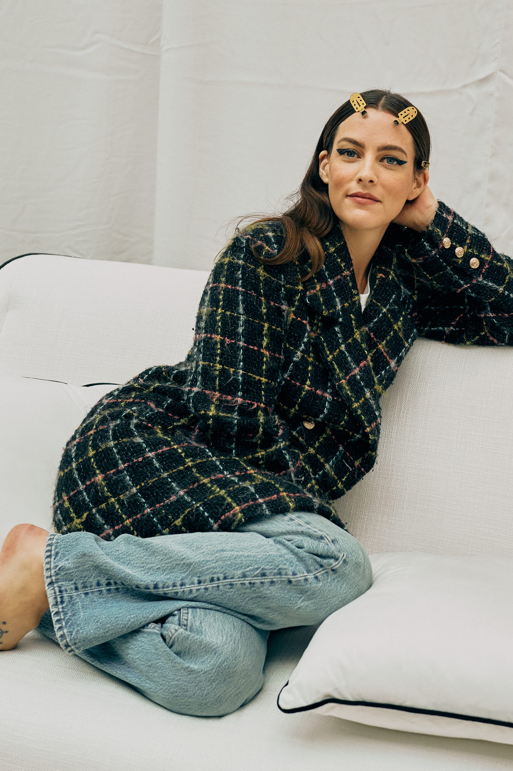 riley keough lounging on a couch