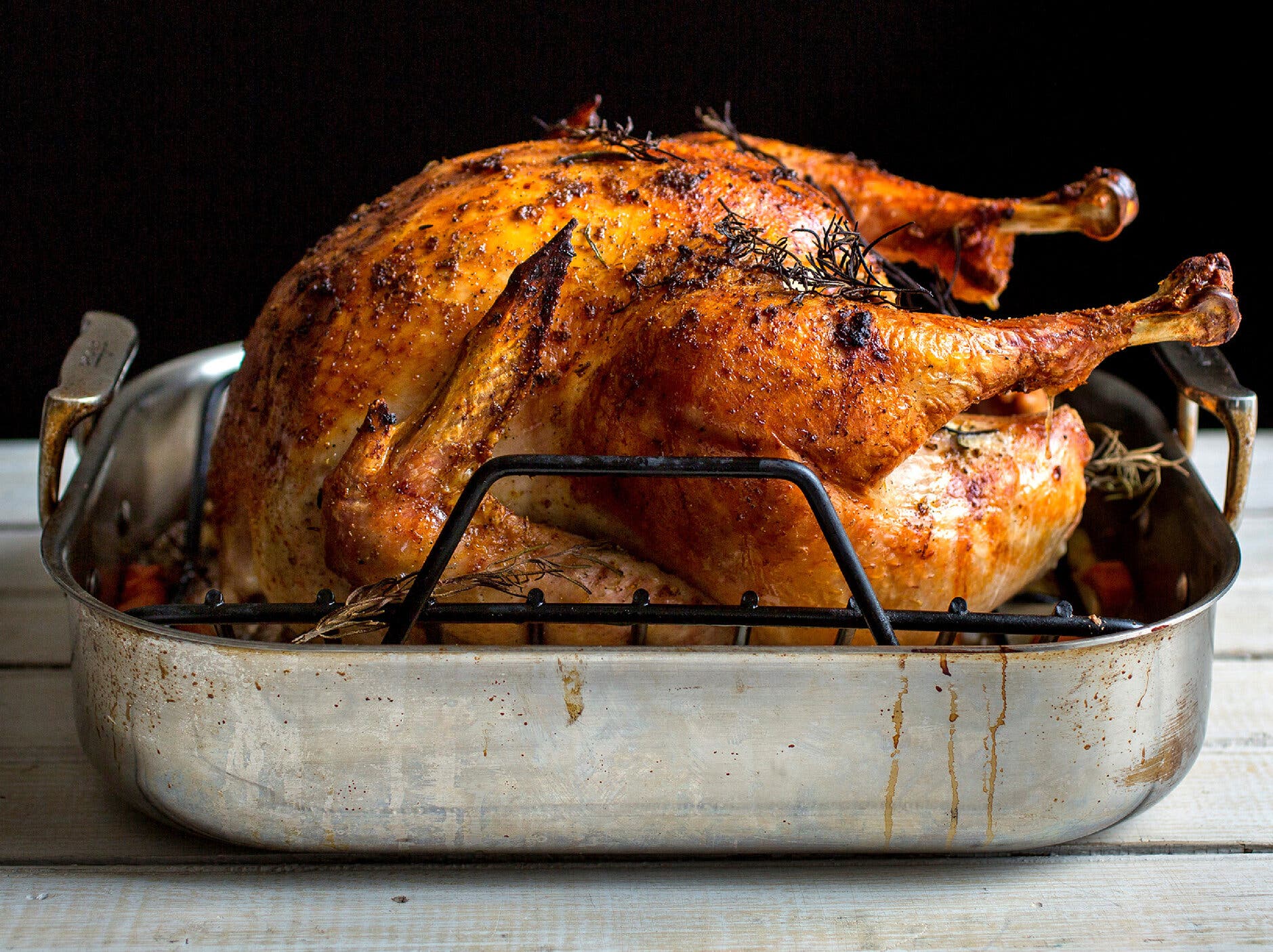 A side image of a burnished turkey in a roasted pan.