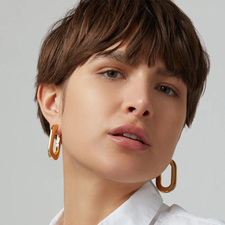 closeup of a person wearing large gold hoop earrings